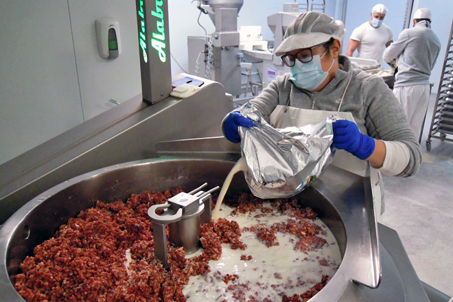 Elena engadindo o leite fresco pasteurizado de Quintián á mestura para facer a masa de croquetas