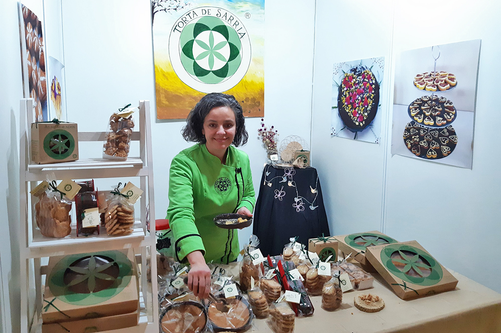 Lourdes, nunha feira antes do covid coa tarta de améndoa e castaña e outros produtos que elabora