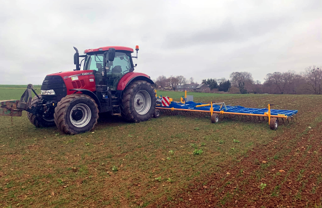 Tractor realizando un pase coa binadora para arrincar as malas herbas nun cultivo ecolóxico